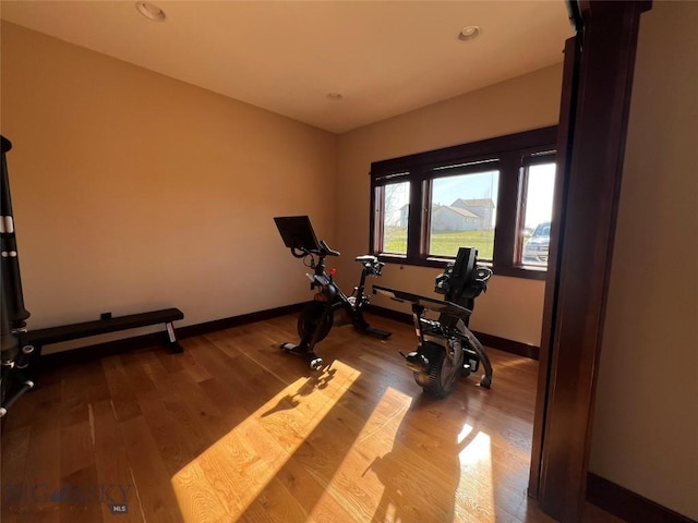 workout area with wood finished floors, recessed lighting, and baseboards
