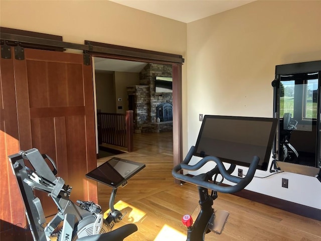 workout room featuring wood finished floors and a fireplace