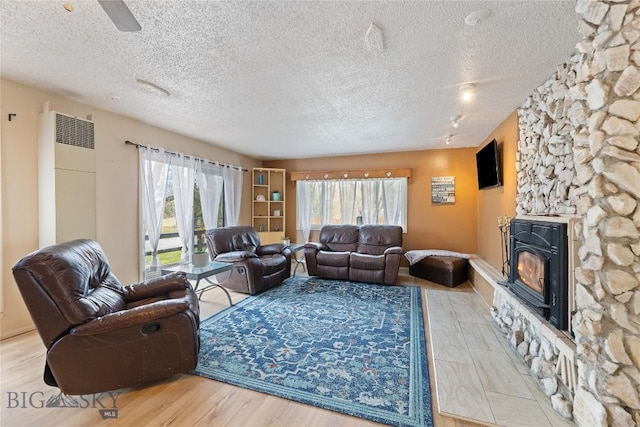 living area featuring a textured ceiling, a ceiling fan, and wood finished floors