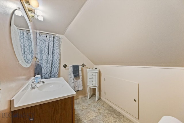 full bath with curtained shower, lofted ceiling, and vanity