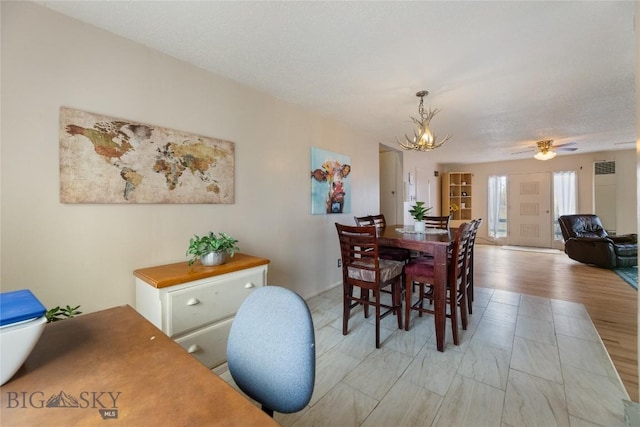 dining space with visible vents and ceiling fan with notable chandelier