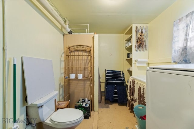 bathroom featuring washer / clothes dryer and toilet