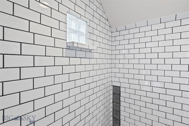 full bath with vaulted ceiling and a tile shower