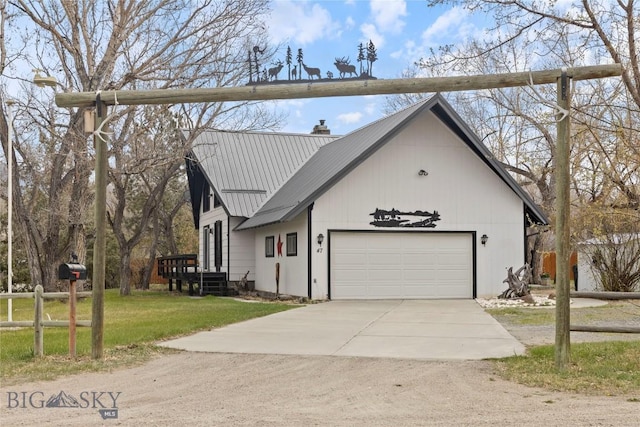 view of front of home with a chimney, metal roof, a front yard, concrete driveway, and an attached garage