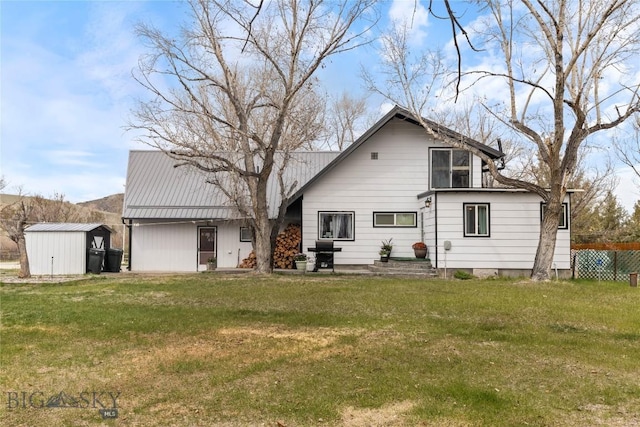 back of property featuring a lawn, a storage unit, and an outdoor structure