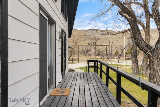 deck with a yard, fence, and a mountain view