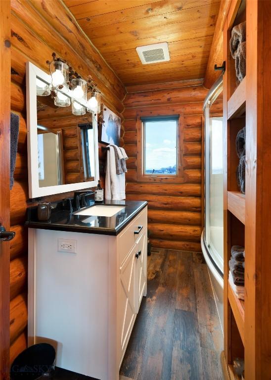 7550 Springhill Rd, Belgrade, MT 59714 - full bath with visible vents, a stall shower, wooden ceiling, rustic walls, and wood-type flooring
