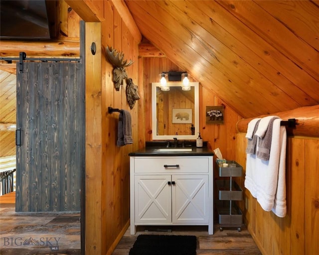 7550 Springhill Rd, Belgrade, MT 59714 - bathroom with wood finished floors, lofted ceiling, wooden walls, and vanity