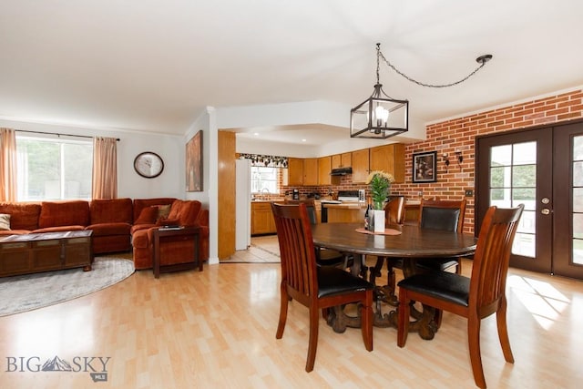 dining room featuring an inviting chandelier, french doors, and light wood-style flooring