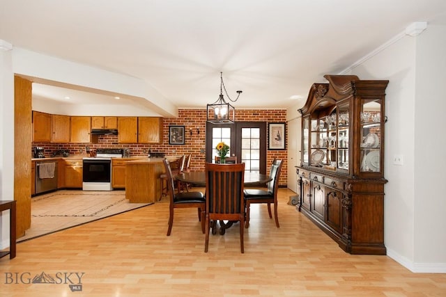 dining space featuring baseboards and light wood-type flooring