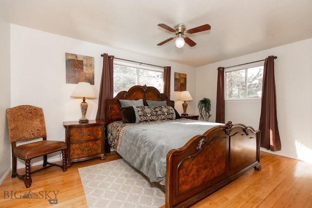 bedroom with baseboards, a ceiling fan, and light wood-type flooring