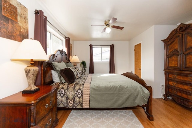 bedroom featuring a ceiling fan, baseboards, and light wood-style floors