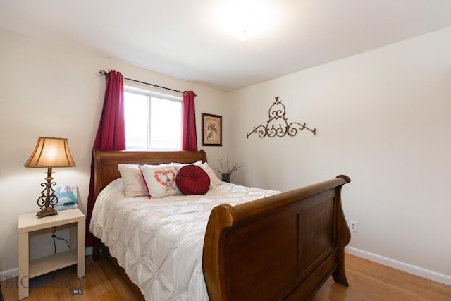 bedroom with baseboards and light wood-style flooring