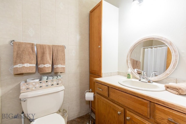 bathroom featuring toilet, tile walls, and vanity