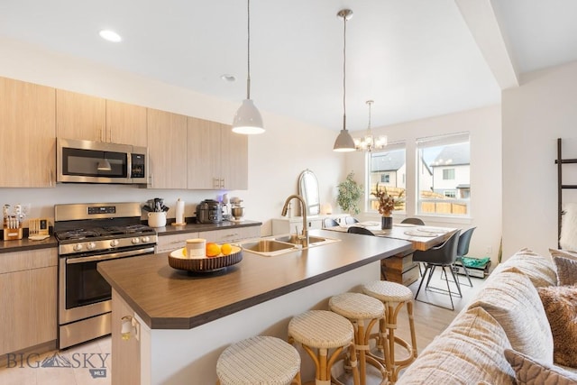 1307 Grover Ln Unit B, Belgrade, MT 59714 - kitchen featuring a sink, light brown cabinetry, a breakfast bar, and stainless steel appliances