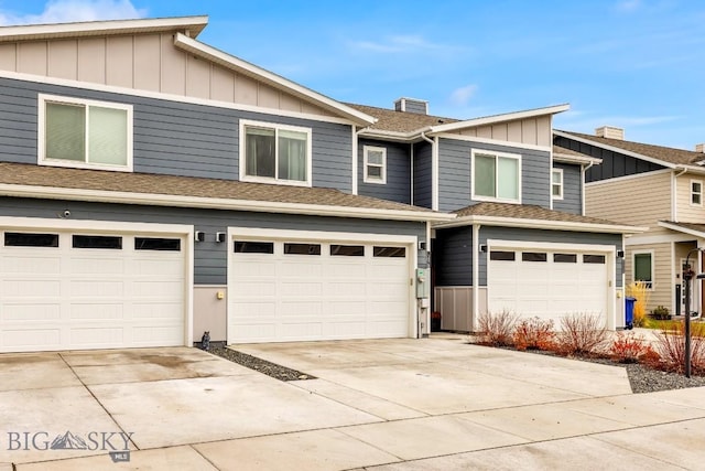 1307 Grover Ln Unit B, Belgrade, MT 59714 - townhome / multi-family property featuring board and batten siding, driveway, a chimney, and a garage