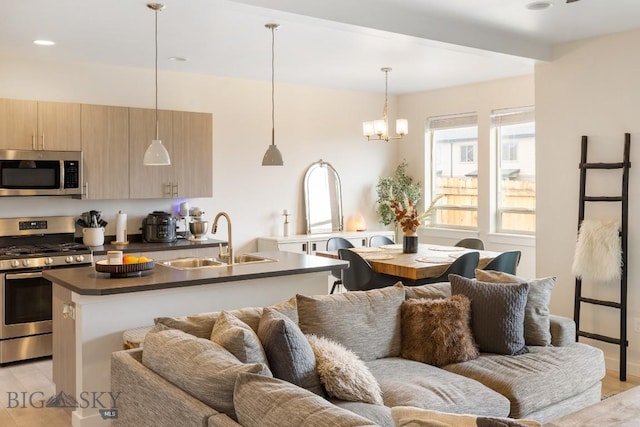 1307 Grover Ln Unit B, Belgrade, MT 59714 - kitchen featuring appliances with stainless steel finishes, dark countertops, light wood-type flooring, a sink, and open floor plan