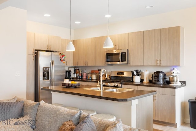 1307 Grover Ln Unit B, Belgrade, MT 59714 - kitchen featuring light brown cabinets, dark countertops, an island with sink, a sink, and stainless steel appliances