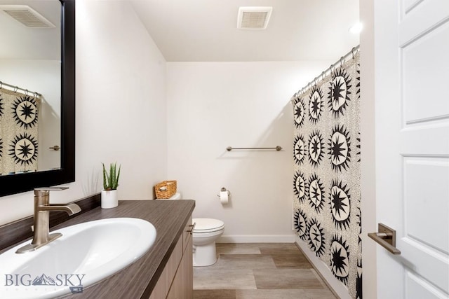 1307 Grover Ln Unit B, Belgrade, MT 59714 - full bathroom featuring vanity, baseboards, toilet, and visible vents