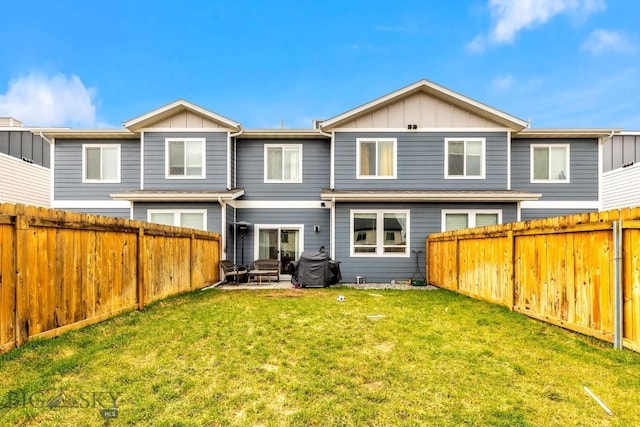1307 Grover Ln Unit B, Belgrade, MT 59714 - back of house with board and batten siding, a patio, a yard, and a fenced backyard