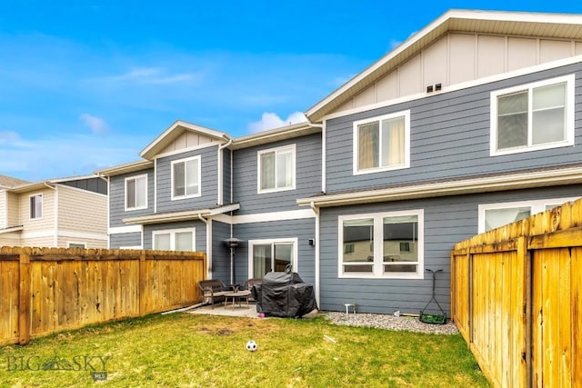 1307 Grover Ln Unit B, Belgrade, MT 59714 - rear view of house with a fenced backyard, board and batten siding, a yard, and a patio area