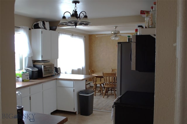 820 Lexington Ave, Butte, MT 59701 - kitchen with ceiling fan with notable chandelier, freestanding refrigerator, white cabinetry, a peninsula, and a toaster