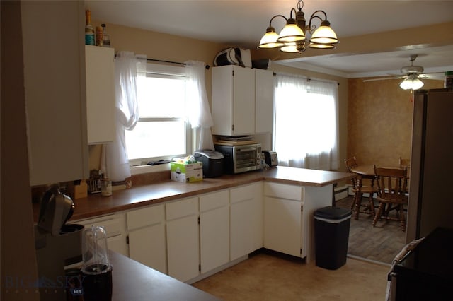 820 Lexington Ave, Butte, MT 59701 - kitchen featuring a toaster, fridge, white cabinets, ceiling fan with notable chandelier, and decorative light fixtures