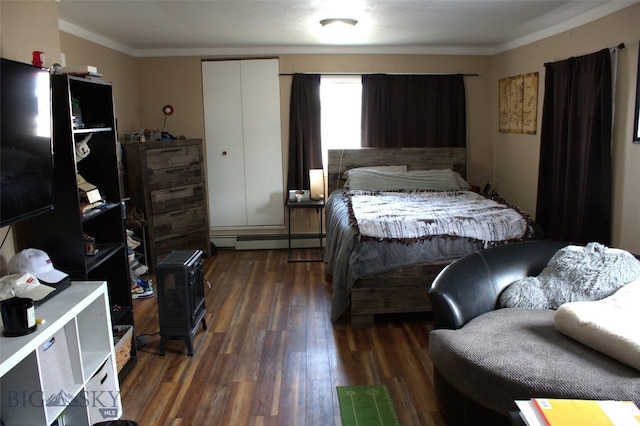 820 Lexington Ave, Butte, MT 59701 - bedroom with crown molding, dark wood-style floors, a wood stove, and a baseboard radiator