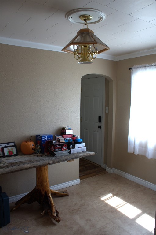 820 Lexington Ave, Butte, MT 59701 - unfurnished dining area featuring baseboards, arched walkways, light floors, and ornamental molding