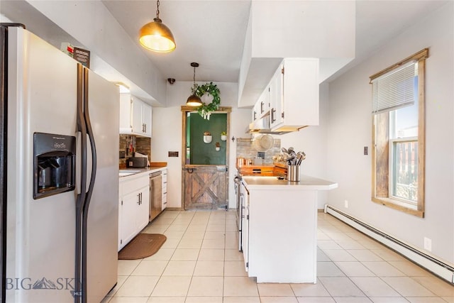 kitchen featuring light countertops, refrigerator with ice dispenser, a baseboard heating unit, and tasteful backsplash
