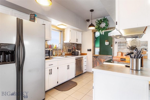kitchen with backsplash, a sink, light countertops, white cabinets, and stainless steel appliances
