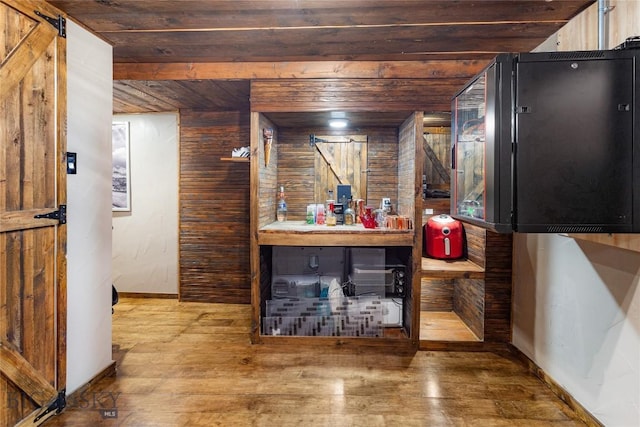 bar featuring wood-type flooring, baseboards, wood walls, and wood ceiling