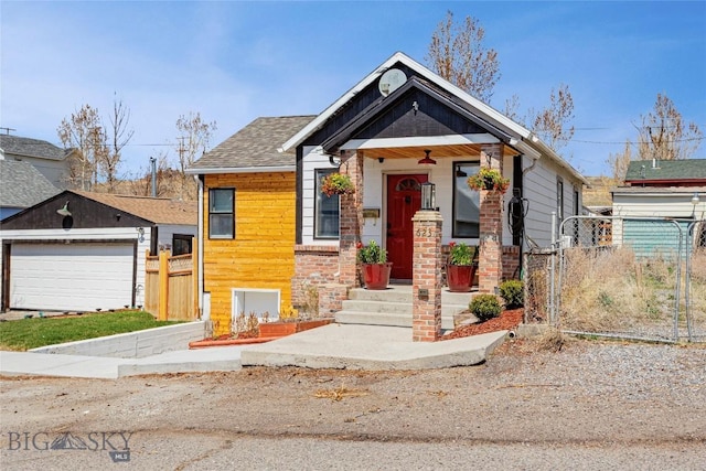 view of front facade featuring fence, a gate, and a shingled roof