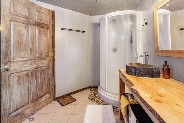 full bathroom featuring vanity, tile patterned floors, baseboards, and a shower stall