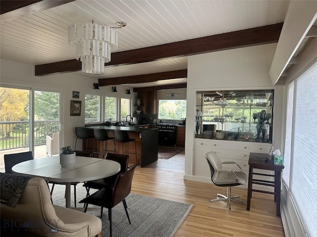 dining area featuring beam ceiling and light wood-style flooring