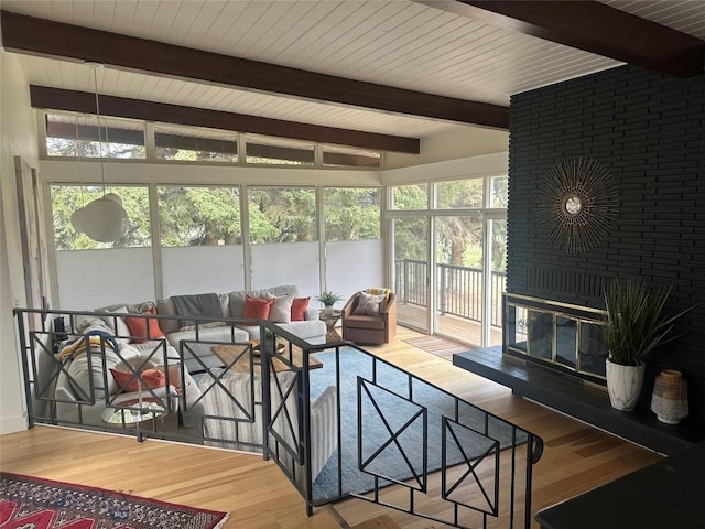 sunroom featuring beamed ceiling and wood finished floors