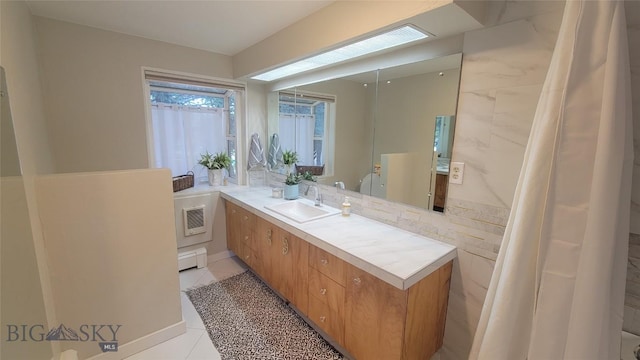 bathroom with vanity, a baseboard radiator, and tile patterned floors