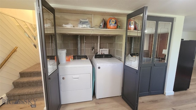 laundry room featuring separate washer and dryer, laundry area, a baseboard heating unit, and light wood-style flooring