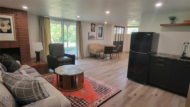 living area featuring recessed lighting, light wood finished floors, and a fireplace