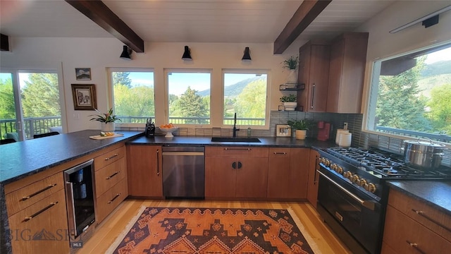 kitchen with a sink, beamed ceiling, stainless steel dishwasher, and range with gas stovetop
