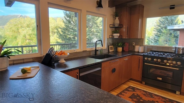 kitchen with backsplash, open shelves, a sink, black appliances, and light wood finished floors