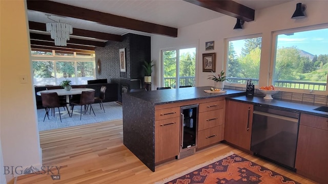kitchen with stainless steel dishwasher, light wood-type flooring, beverage cooler, and a wealth of natural light