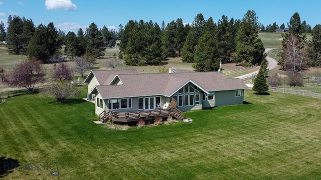 back of property featuring fence, a yard, and a wooden deck