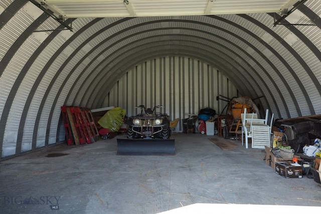 miscellaneous room featuring a garage, vaulted ceiling, and concrete floors