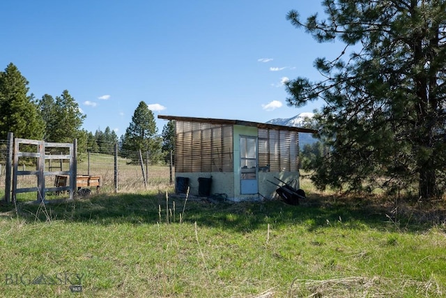 view of outdoor structure featuring fence and an outbuilding