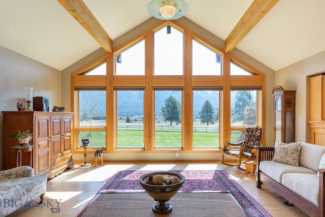 living area featuring light wood-style flooring, beam ceiling, and high vaulted ceiling