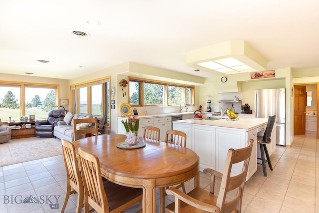 dining space with visible vents, light tile patterned floors, and a healthy amount of sunlight
