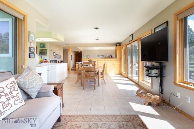 living room featuring french doors, light tile patterned floors, and a wealth of natural light