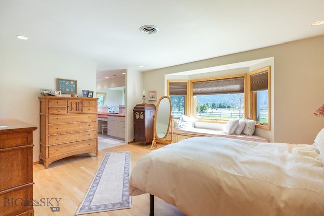 bedroom with light wood-style floors, recessed lighting, ensuite bath, and visible vents
