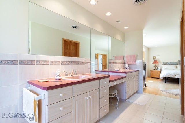 full bath featuring vanity, visible vents, tile patterned flooring, and ensuite bath